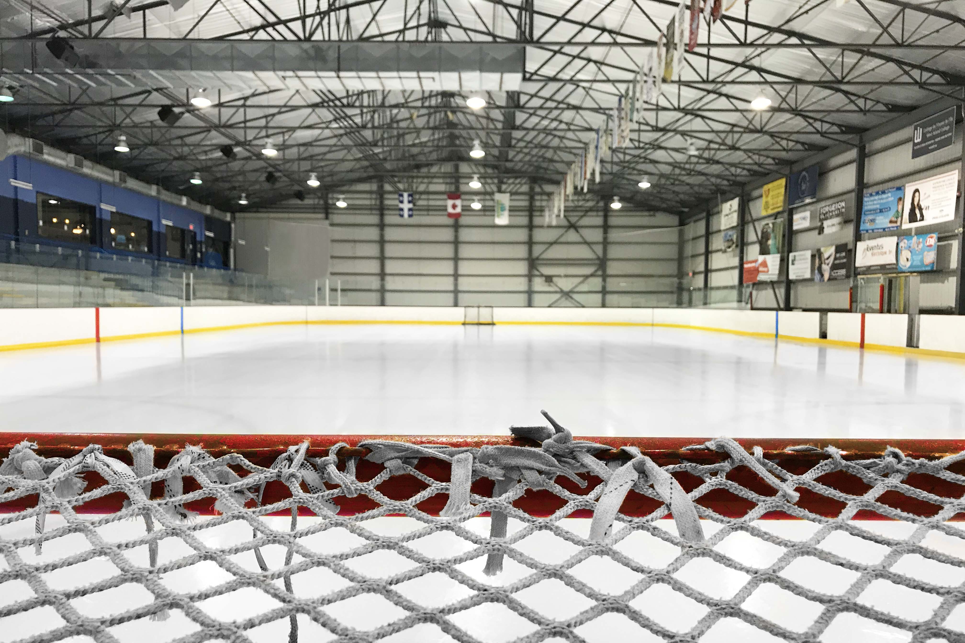 Hockey net with arena in the background.